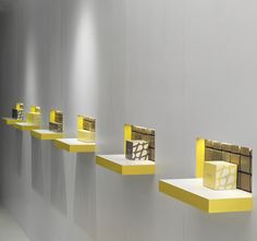 several yellow shelves are lined up against the wall in an empty room with white walls