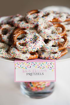 a plate full of pretzels on top of a table with a sign that says pretzels