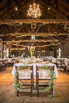 the tables are set up with white linens, greenery and chandeliers