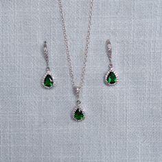 "This sparkly delicate handmade classic cubic zirconia CZ teardrop necklace and earring set features dangle bridal earrings and necklace made with 6x8mm emerald green pear cut CZs circled by a halo of small clear round brilliant cut CZs dangling from CZ french hooks and a CZ bail on a 925 sterling silver rolo chain. The drops are white goldplate and the hooks and bail are rhodiumplate. Really beautiful quality and amazing sparkle perfect for your wedding or special occasion! For pierced ears.  Measurements:  Earrings:  1-1/8\" L x 3/8\" W Necklace:  18\" L Drop:  7/8\" L x 3/8\" W   Please choose earrings only, necklace only or a set from the pull-down menu. Why cubic zirconia? CZ is hard, optically flawless, usually colorless and is available in a variety of different colors. Because of i