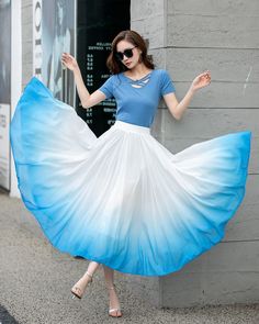 "Elevate your style with our white and blue gradient high-waisted chiffon swing skirt. The ombre color transition from white to blue adds a touch of whimsy and charm. The high-waisted design cinches your waist and elongates your legs for a flattering silhouette. Crafted from lightweight chiffon fabric, this skirt is comfortable and allows for easy movement. The swing style creates a playful and romantic look, perfect for summer events and beach outings. Embrace the beauty of the ombre trend with Ombre Fabric Fashion, White And Blue Skirt Outfit, Ombre Tops For Women, White Chiffon Skirt For Spring, White Gathered Maxi Skirt For Summer, White Chiffon Skirted Bottoms, Summer White Pleated Ruffled Skirt, White Flowy Gathered Maxi Skirt, White Gathered Skirt For Summer