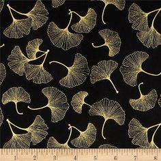 a black background with gold leaves on it and a ruler in front of the image