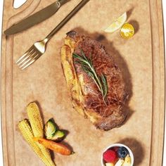 a tray with some food on it and utensils next to it, including a steak