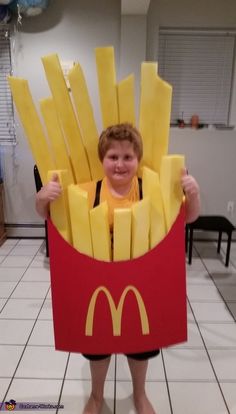 a young boy is dressed up as a mcdonald's fries costume