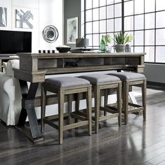 a dining room table with four stools and a tv