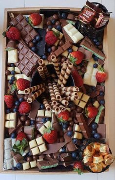 a box filled with assorted chocolates and strawberries on top of a table