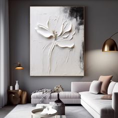 a modern living room with white furniture and large painting on the wall above it's coffee table