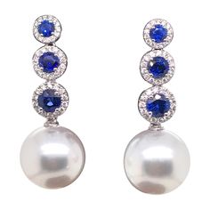 18K White gold drop earrings featuring 6 blue sapphires, 1.50 carats, flanked with round brilliants weighing 0.37 carats and two South Sea Pearls measuring 12-13 mm Color G-H Clarity SI White Gold Drop Earrings, South Sea Pearls Earrings, Tahitian Black Pearls, Bezel Set Diamond, Sea Pearl, White Gold Earrings, South Sea Pearls, Sea Pearls, Diamond Drop Earrings