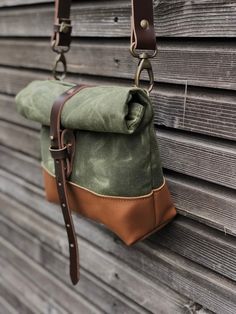 This day bag / satchel is your perfect companion for the days when you only need some necessities to take with you. The day bag is made in heavy weight waxed  canvas in color olive green, with roll to close top, with snap and strap closing. Made it with a brown leather bottom, for extra durability and strength. Phone pocket on the backside closing with pouch button. With adjustable and detachable shoulder strap in vegetable tanned leather Fully lined with a cotton canvas  The size of this bag me Khaki Adventure Bags With Waxed Finish, Khaki Adventure Bag With Waxed Finish, Adventure Khaki Bags With Waxed Finish, Khaki Waxed Finish Adventure Bag, Canvas Satchel Bag For Adventure, Khaki Backpack With Waxed Finish, Khaki Canvas Shoulder Bag With Waxed Finish, Canvas Satchel For Adventure, Green Canvas Satchel With Adjustable Strap