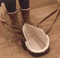 a person wearing boots and carrying a bag on the floor with their feet in the air