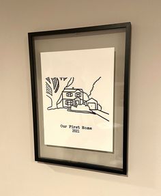 a black frame hanging on the wall with a drawing in front of it that says our planet home