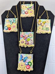 four necklaces with different designs on them