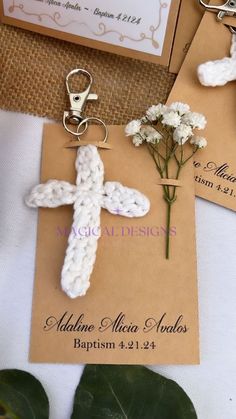 a cross keychain with flowers on top of it next to a card and some other items