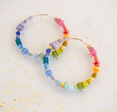 Set of Rainbow beaded hoop earrings DETAILS: 45mm hoops Gold filled hoops Earring post are lead and nickel free.  *Beads may vary slightly. PACKING AND SHIPPING: Please do not use the notes section of your order to relay time sensitive information (such as needing an address change). If you need to relay information regarding shipping, please message us directly. Requesting an arrival date in the notes section of your order does not guarantee it will arrive by that day, but we'll do our best! Pl Gay Pride Jewelry, Pride Earrings, Pride Jewelry, Pride Jewellery, Hoops Gold, Celestial Necklace, Gold Filled Hoops, Rainbow Beads, Mom Jewelry