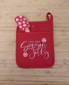 a red oven mitt sitting on top of a wooden table