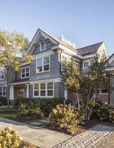 a large gray house with white trim and windows