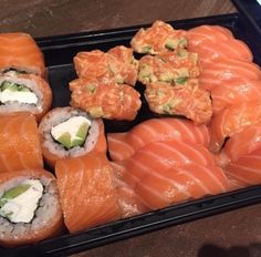 sushi platter with salmon, avocado and cucumber on it