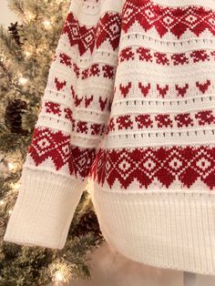 a red and white sweater hanging on a christmas tree