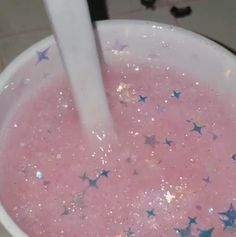 a white bowl filled with pink liquid and blue stars