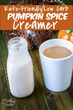 a cup of pumpkin spice creamer next to a jar of milk on a wooden table