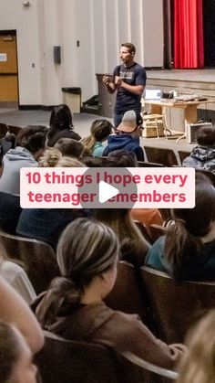 there is a man standing in front of an audience with his hands on his hips