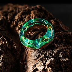 "Wood Resin Ring Made of Epoxy Resin and Exotic Wood. Green Resin Jewelry with Magic. Makes a Great Gift. Present this unusual ring! I hand select only the highest quality of wood from noble tree species that encase a piece of nature, spirit and energy from the place where it was growing. I finish the wood with natural and eco-friendly carnauba wax and flaxseed oil to give a wonderful matte lustre as well as make it weatherproof. The resin has a high clarity, hardness and optimal light refractio Unique Resin Crystal Ring Gift, Unique Resin Rings For Gifts, Unique Green Resin Ring, Unique Green Resin Rings, Tree Species, Unusual Rings, Flaxseed Oil, Nature Ring, Resin Ring