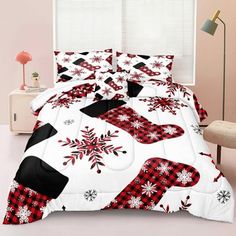 a bed covered in red and black snowflakes next to a white chair