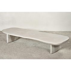 a white bench sitting on top of a cement floor