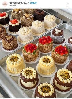 there are many different cakes on display in the trays and one is white, brown, and red