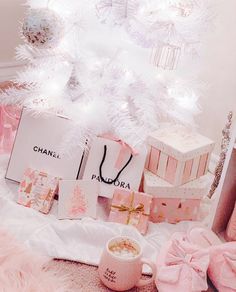 a white christmas tree decorated with pink presents