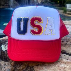 a red, white and blue hat with the word usa on it sitting next to a pool