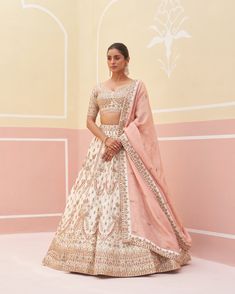 Ivory Raw Silk Lehnga Set | Angad Singh An exquisite ivory double dupatta lehenga set, this ensemble is a masterpiece of traditional zardozi embroidery. Adorned with silken threads, dabka, cutdana, and sequins, it reflects a rich heritage of craftsmanship. The intricate detailing on the lehenga, combined with the elegance of the double dupatta, creates a luxurious and sophisticated look, making it an ideal choice for weddings, festivals, and other special occasions. The subtle yet opulent design ensures you stand out with grace and timeless beauty. Included in Purchase: Lehenga, Blouse and Dupatta Product Specification Color: Ivory Fabric: Raw Silk with Crape Lining Occasion: Wedding, Engagement, Formal Event Designer: Angad Singh Work: Hand Embroidery *Jewelry sold separatelyCustomization White Raw Silk Lehenga With Intricate Embroidery, White Lehenga With Intricate Embroidery In Raw Silk, White Art Silk Lehenga With Intricate Embroidery, Traditional Drape Raw Silk Cream Choli, Bollywood Style Cream Choli With Cutdana, Traditional Drape Cream Raw Silk Choli, Bollywood Style Off White Raw Silk Set, Off White Bollywood Raw Silk Set, Traditional Cream Raw Silk Choli