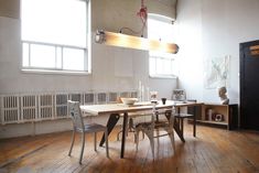 an empty room with a table and two chairs in front of a radiator