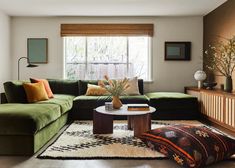 a living room filled with green couches and pillows on top of a white rug