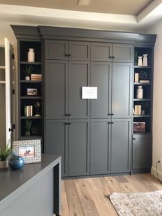 a room with gray cabinets and wooden floors