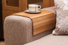 a cup and saucer sitting on top of a wooden table next to a couch