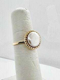 Different from your normal round pearls, this ring has a cultured coin pearl set into a 14k yellow gold buttercup setting for a nice low profile statement ring.  Currently a size 5 3/4, but can be sized at no additional cost! Classic Round Pearl Ring With Pearl Drop, Classic Pearl Ring With Pearl Drop, Yellow Gold Round Rings With Pearl Drop, Adjustable Pearl Ring For Formal Occasions, Adjustable Pearl Drop Round Rings, Adjustable Formal Pearl Ring, Heirloom Pearl Round Ring, Heirloom Round Pearl Rings, Gold Round Pearl Charm Ring