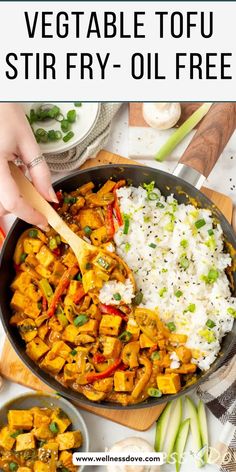 a pan filled with vegetables and rice on top of a wooden cutting board next to other dishes