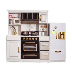 a toy kitchen with white cabinets and gold accents