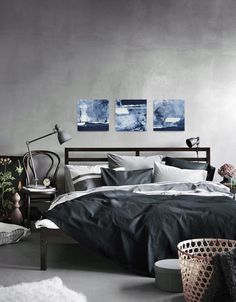 a bedroom with gray walls and black bedding in the middle, white rugs on the floor