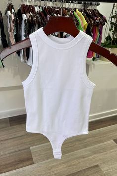 The White Tank Rib Bodysuit is perfect for a night out. Crafted with a ribbed fabric and cut for a body-hugging fit, this bodysuit will keep you looking stylish and feeling comfortable all night long. The tank ribbed design fits snug to your figure, making a sleek statement. Complete your look with a pair of jeans or a skirt for a night of fun. Fabric & fit: 92% nylon 8% spandex Model is wearing size Small. Cotton Ribbed Solid Bodysuit, Cotton Ribbed Solid Color Bodysuit, Summer High Stretch Ribbed Tank Top, Ribbed Fitted Bodysuit For Spring, Solid Spring Bodysuit With Seamless Construction, Fitted Ribbed Tank Bodysuit, Trendy Tank Bodysuit Seamless, Trendy Ribbed Sleeveless Bodysuit, Solid Seamless Spring Bodysuit