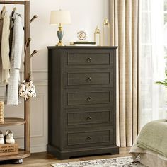 a bedroom with a bed, mirror and dresser in it's corner next to a window