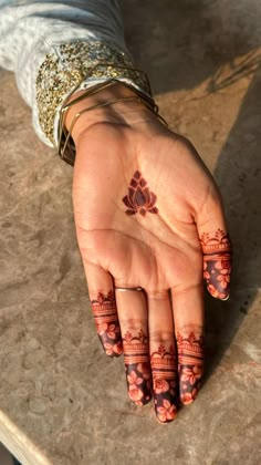 a woman's hand with henna tattoos on it