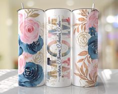 three white cans with blue and pink flowers on them