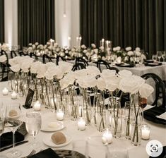 a long table is set with candles and flowers in vases for centerpieces