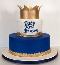 a blue and white cake with a gold crown on top that says baby krus bryson