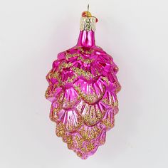 a pink glass ornament with gold trimmings on it's side