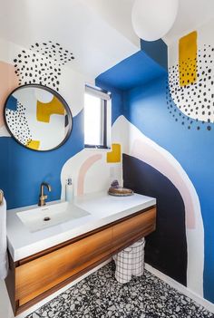 a bathroom with blue, yellow and white paint on the walls next to a sink