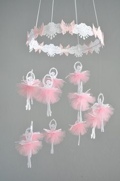 pink and white ballerinas hanging from a chandelier with butterflies on them