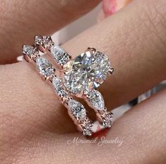 a woman's hand with a diamond ring on top of her finger and an engagement band